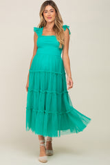 woman wearing a teal maternity maxi dress with ruffled straps and tiered layers