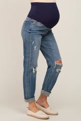 woman wearing distressed light blue maternity jeans with a navy blue belly panel and showing a baby bump