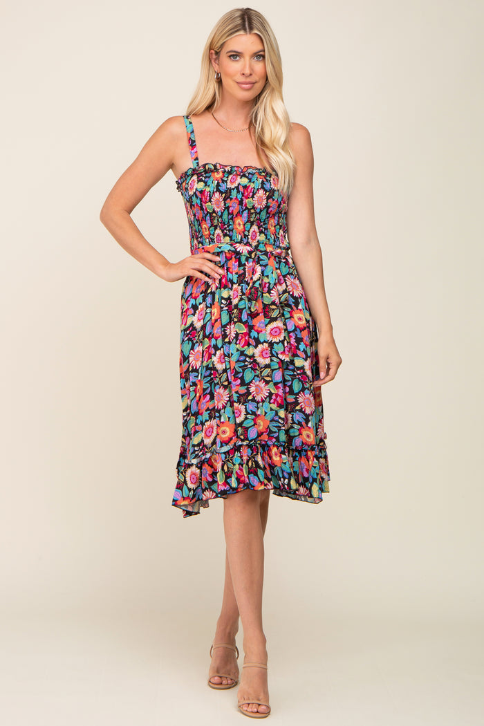 woman wearing a black floral print sundress with spaghetti straps and a smocked bodice