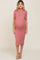 woman wearing a dusty rose ribbed maternity dress with a high neck and short sleeves, showing her baby bump
