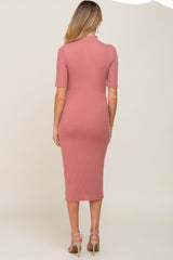 woman wearing a rose pink ribbed maternity dress with short sleeves and a fitted silhouette