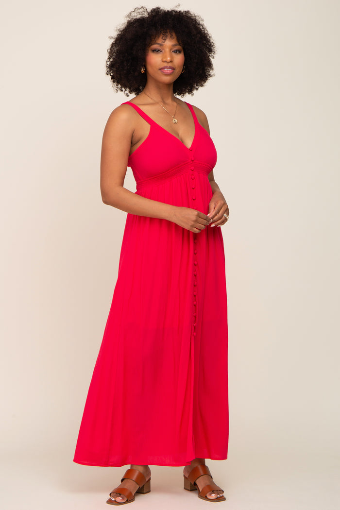 woman with curly hair wearing a sleeveless red maxi dress with button details and brown sandals