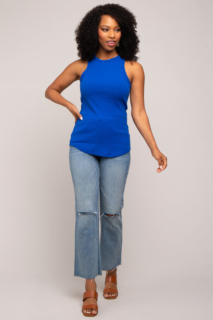 woman wearing a bright blue ribbed tank top and distressed light wash jeans with heeled sandals
