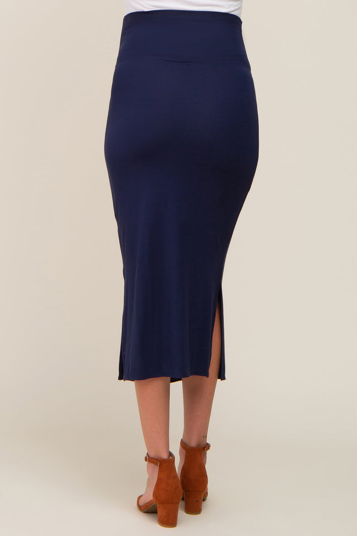 Back view of a woman wearing a navy blue midi skirt with side slits and brown suede block heel sandals