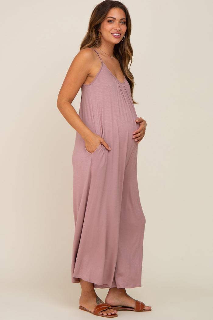 woman wearing a light pink maternity maxi dress with pockets and a visible baby bump