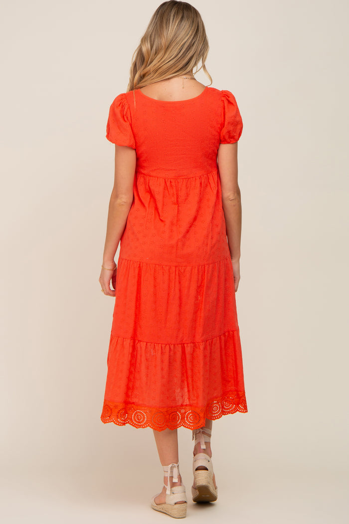 Back view of a woman wearing a red tiered eyelet midi dress with puff sleeves and espadrille wedges