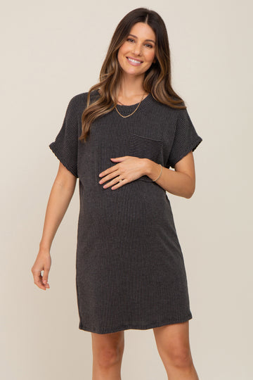 woman wearing a black and gray striped maternity dress with a pocket, gently holding her baby bump