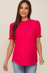 woman wearing a bright pink short sleeve maternity top with ruffle details and a baby bump visible
