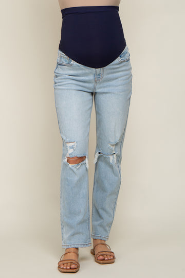 woman wearing light blue distressed maternity jeans with a high navy waistband
