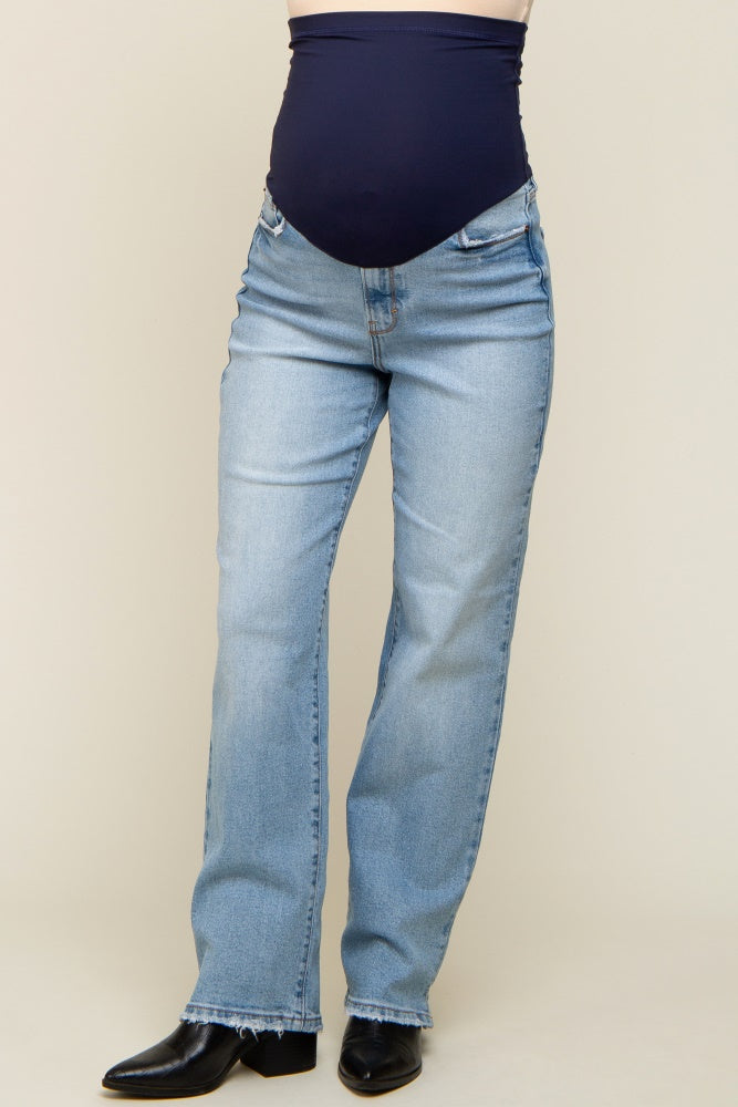 woman wearing light wash maternity jeans with a dark blue belly band.