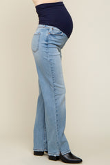 woman wearing light blue maternity jeans with a navy blue belly panel and a visible baby bump