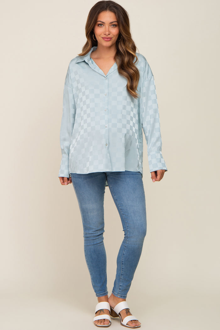 woman wearing light blue checkered satin button down shirt and blue skinny jeans
