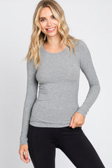 woman wearing a fitted gray long sleeve top with a ribbed texture and black leggings