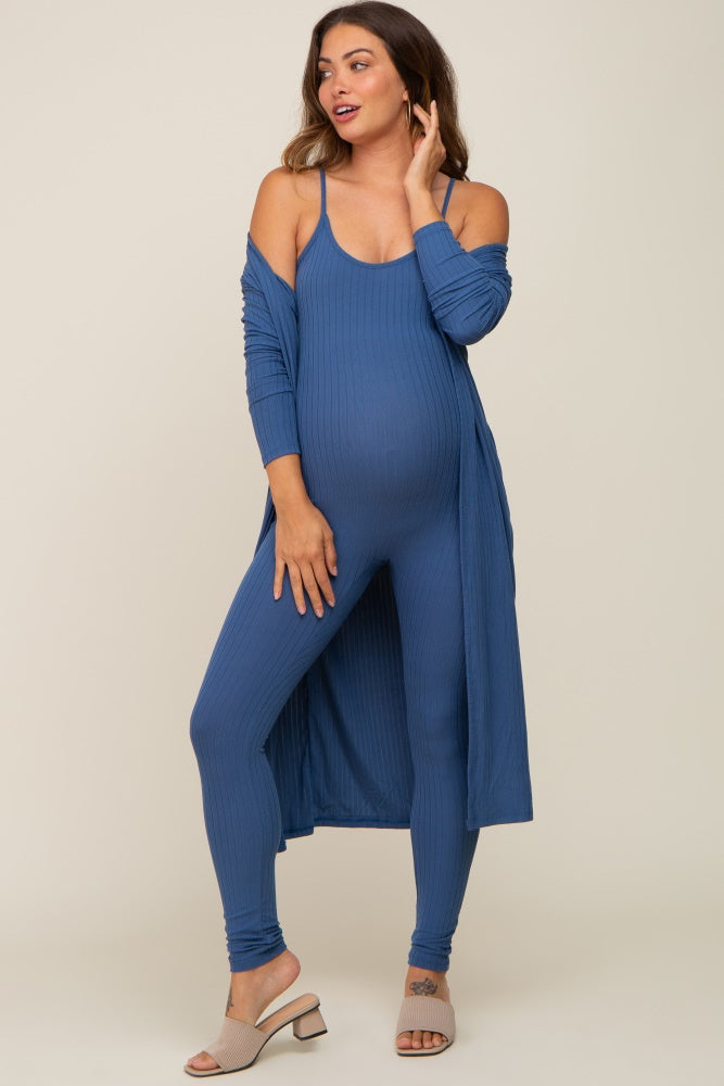 woman wearing a blue maternity ribbed jumpsuit with a matching long cardigan and showing her baby bump