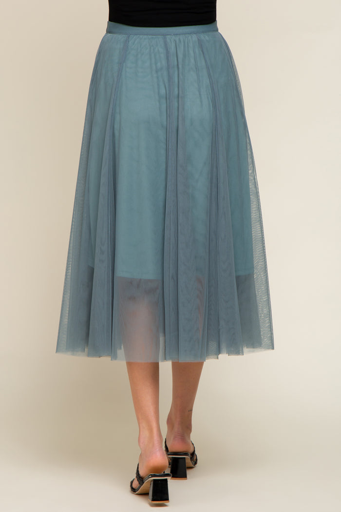woman wearing a long teal tulle maternity skirt, showing the flowy design and sheer layers from the back