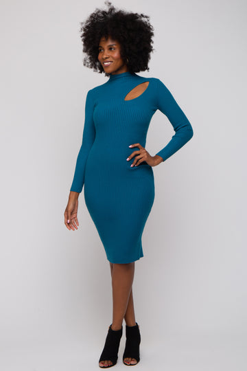 woman wearing a teal ribbed long sleeve dress with a cutout detail on the side and black heeled ankle boots