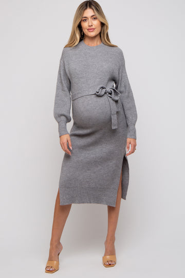woman wearing a gray ribbed maternity dress with a tie waist and side slit, showcasing her baby bump