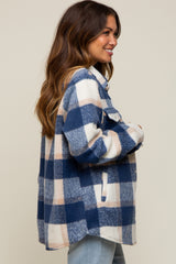 woman wearing a navy and cream plaid maternity shacket with side pockets and a relaxed fit