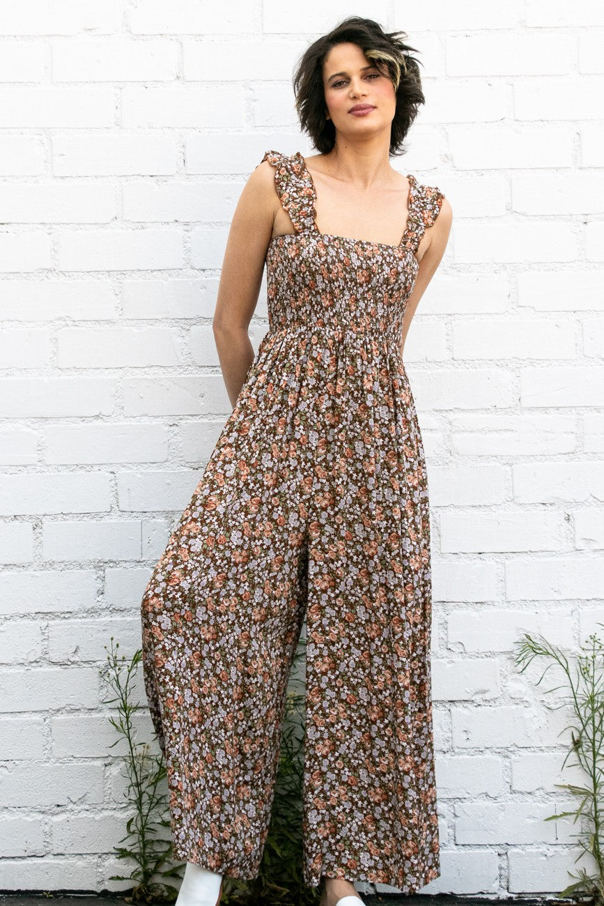woman wearing a brown floral print jumpsuit with ruffled straps and wide legs