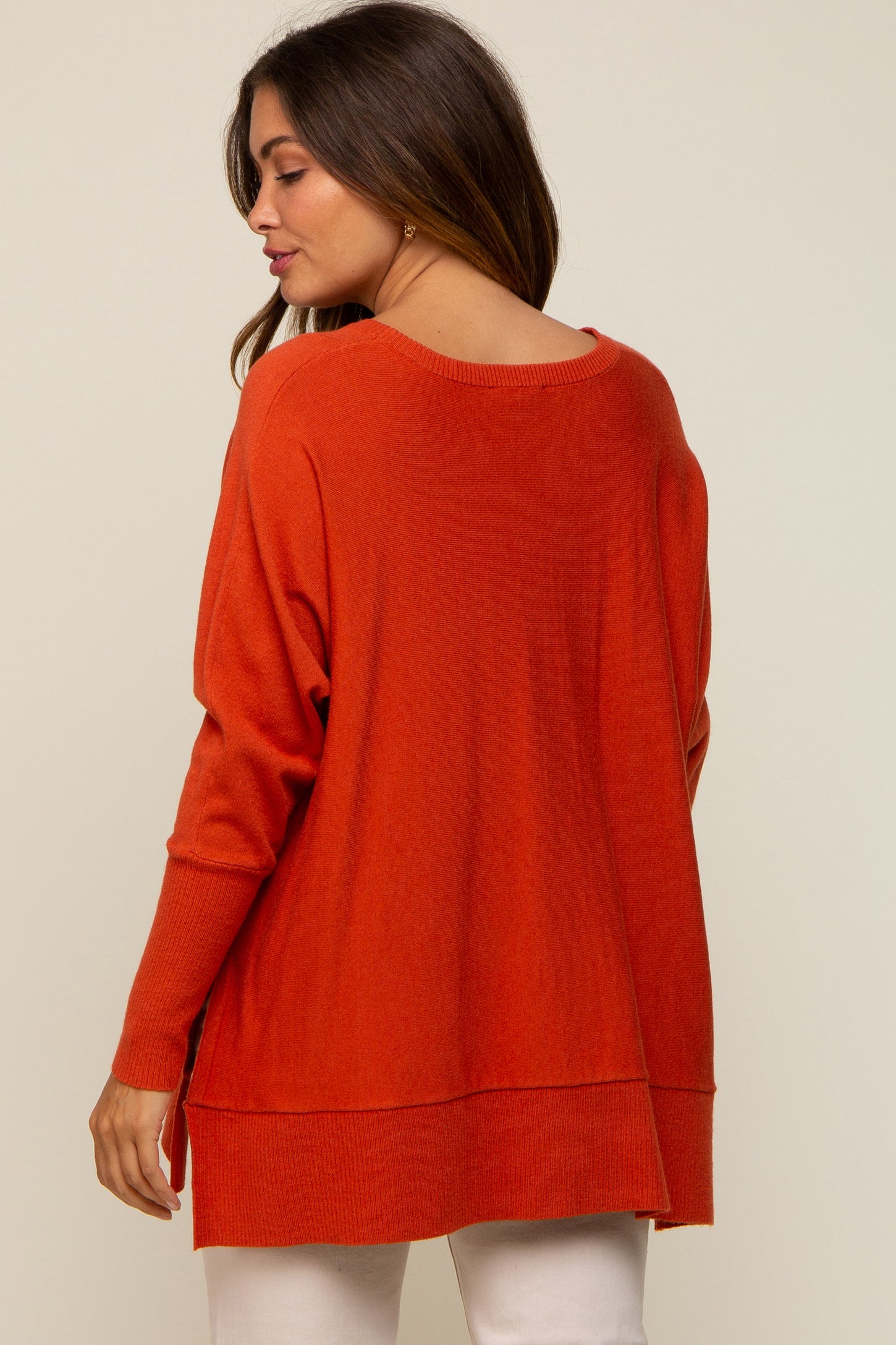 woman wearing an orange maternity sweater with a loose fit and side slits