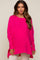 woman wearing a bright pink oversized maternity sweater with long sleeves and a high-low hemline