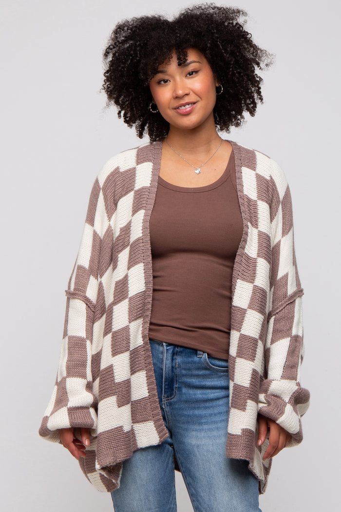 woman wearing a brown and cream checkered oversized cardigan over a brown top, paired with light blue jeans