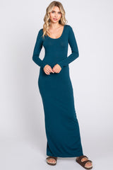 woman wearing a dark teal long sleeve maxi dress with a scoop neck and fitted silhouette