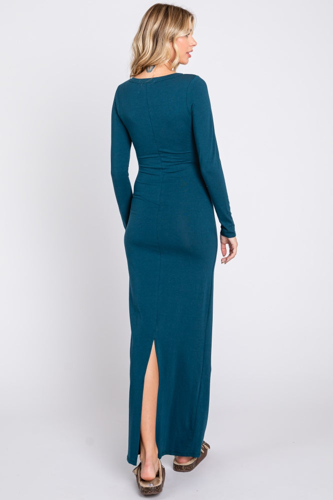 woman wearing a teal long sleeve maxi dress with a side slit and fitted silhouette, viewed from the back