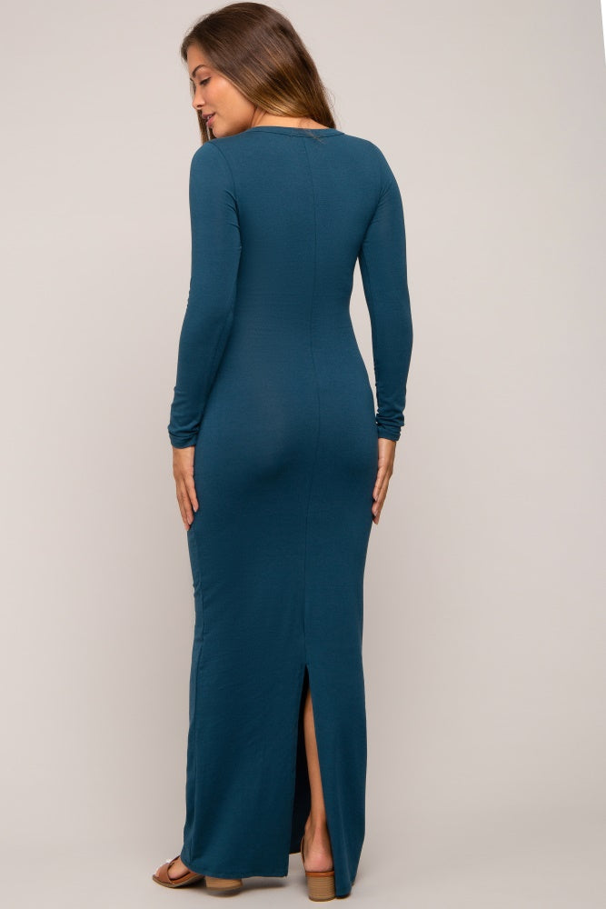 woman wearing a teal long sleeve maternity dress with a back slit, showcasing a fitted silhouette