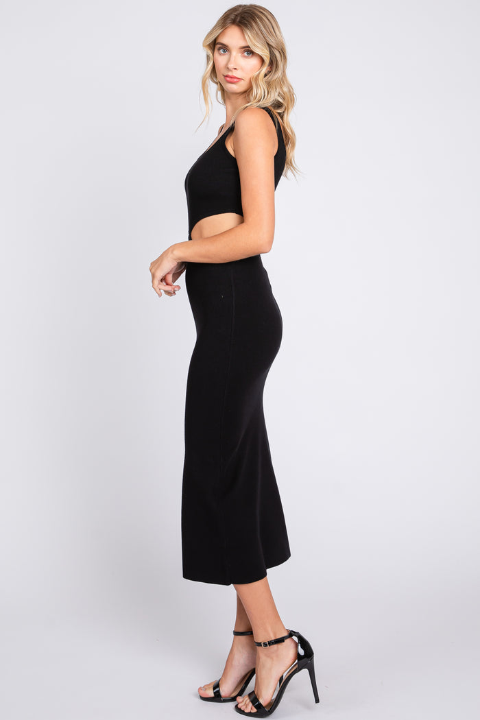 woman wearing a black fitted knit midi dress with a sleeveless design and side slit, paired with black heels