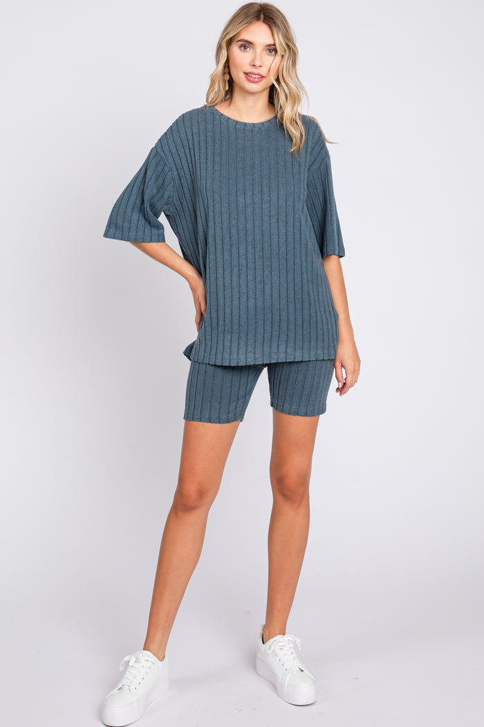 woman wearing a teal ribbed knit oversized top and matching shorts with white sneakers
