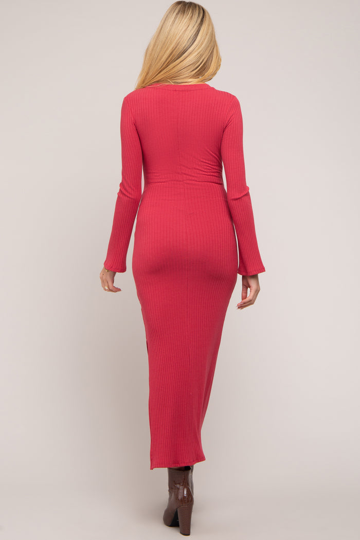woman wearing a fitted raspberry long sleeve maternity dress with a round neck and a floor-length silhouette