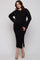 woman wearing a black ribbed long sleeve maternity dress with side slits and a visible baby bump