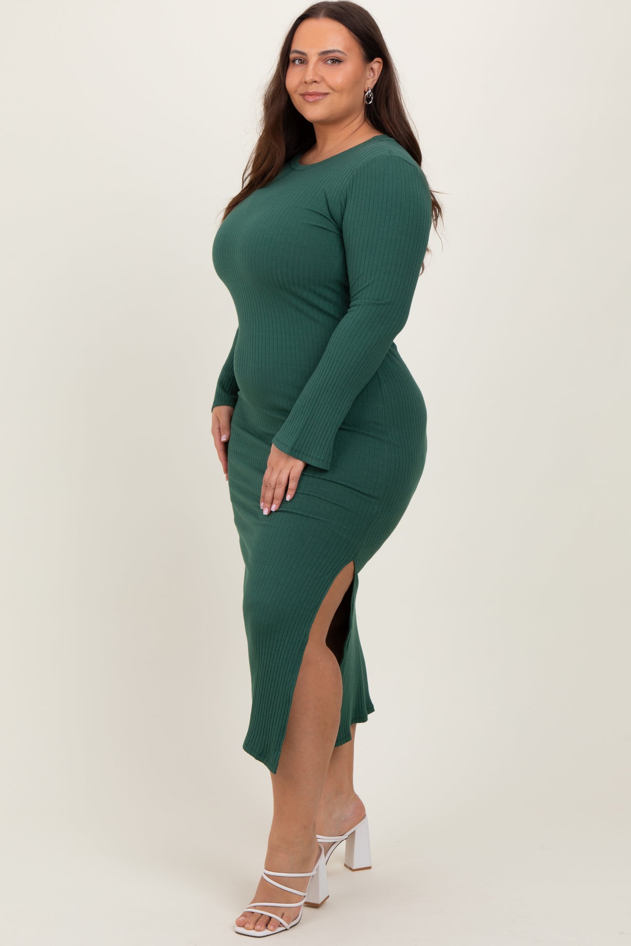 woman wearing a long sleeve olive green ribbed midi dress with side slits and styled with high heel sandals