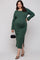 woman wearing a green ribbed maternity dress with long sleeves and a side slit, holding a black handbag and showing her baby bump