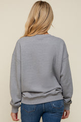 woman wearing a gray oversized maternity sweatshirt with a relaxed fit and ribbed cuffs, viewed from the back