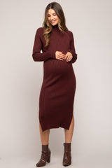 woman wearing a burgundy ribbed maternity dress with long sleeves and a side slit, showing her baby bump