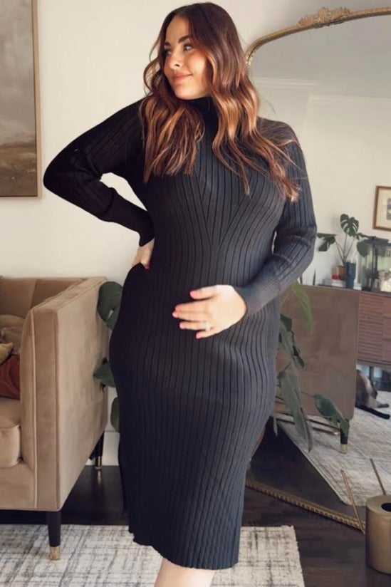 woman wearing a black ribbed maternity dress and holding her baby bump