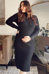 woman wearing a black ribbed maternity dress and holding her baby bump