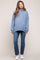 woman wearing a light blue oversized hoodie and skinny jeans, showing her baby bump