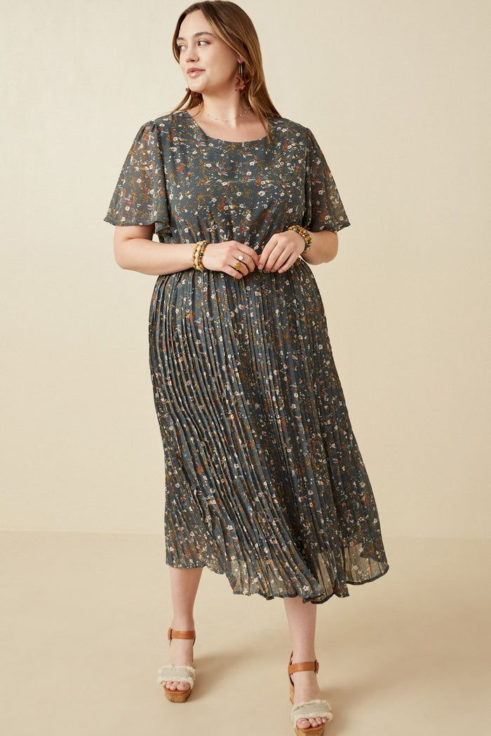 woman wearing a dark floral plus size midi dress with pleated skirt and short sleeves, standing against a neutral background
