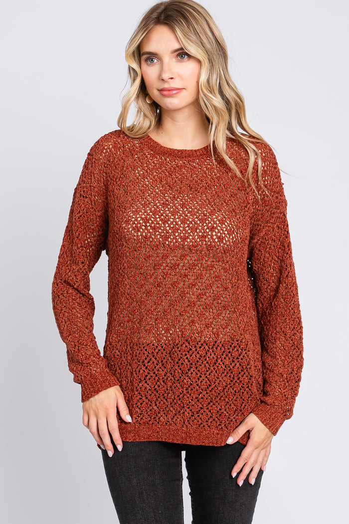 woman wearing a rust-colored open knit sweater with long sleeves and a relaxed fit
