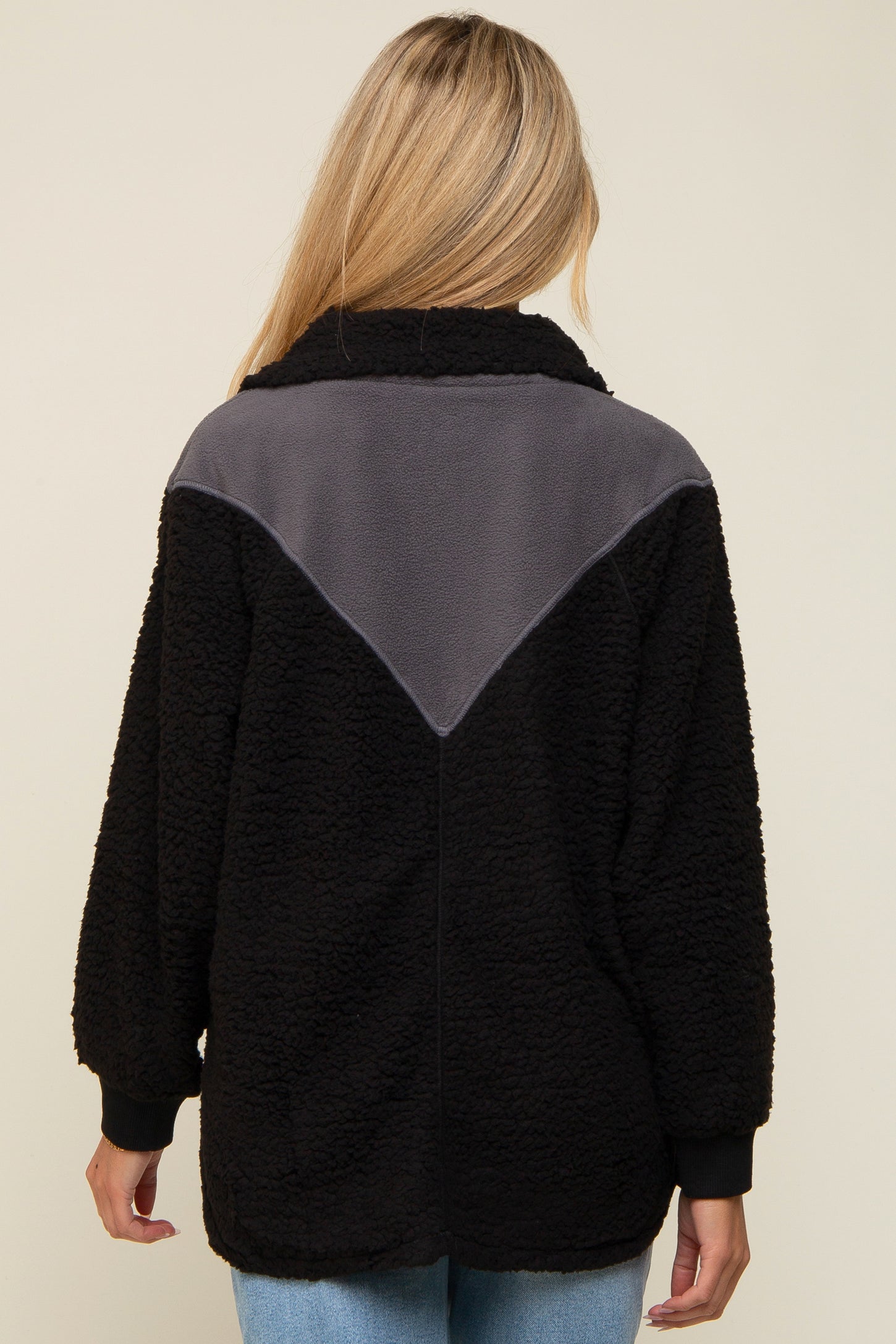 woman wearing a black and gray maternity fleece jacket with a relaxed fit and a high collar, seen from the back