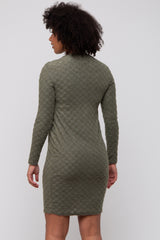 woman wearing an olive green long sleeve knit dress with a textured check pattern, seen from the back