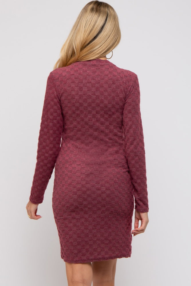 woman wearing a burgundy long sleeve fitted maternity dress with textured detail from the back