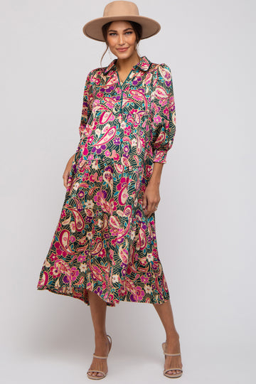woman wearing a colorful printed maternity dress with a button-down front and three-quarter sleeves, showing her baby bump
