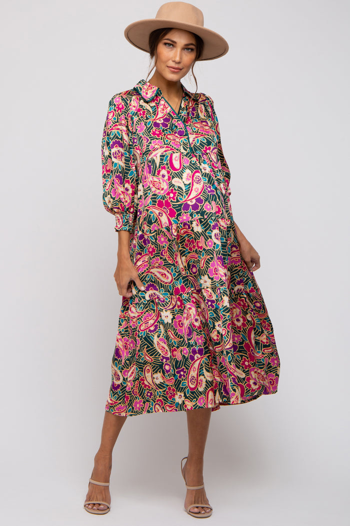 woman wearing a colorful floral print maternity dress with a button-up collar and 3/4 sleeves, showing a baby bump