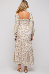 woman wearing a floral maternity maxi dress with long sleeves and a square neckline, showing a modest back design