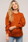 woman wearing an orange oversized maternity sweater with long sleeves and a relaxed fit, showing her baby bump