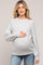 woman wearing a light gray maternity sweater and holding her baby bump